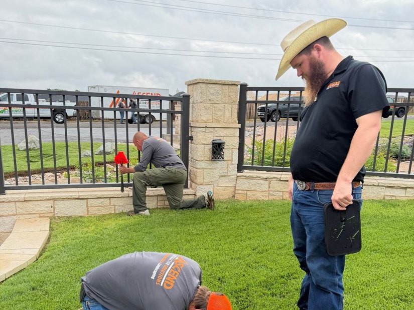 Ascend crew checking a valve box and backflow assembly ahead of winter