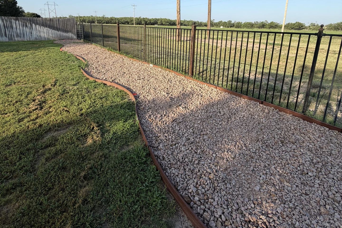 After: gravel path with steel edging along the same fence
