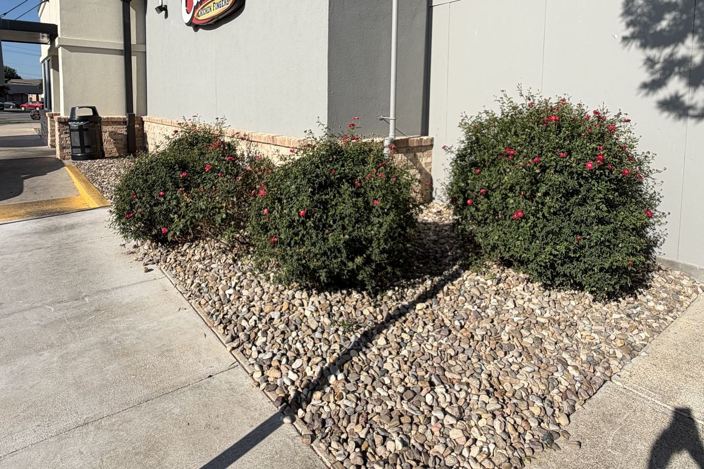 After: the same beds finished with river rock